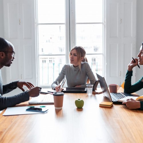 Shot of three business colleagues working together in modern workspace. Brainstorming concept.